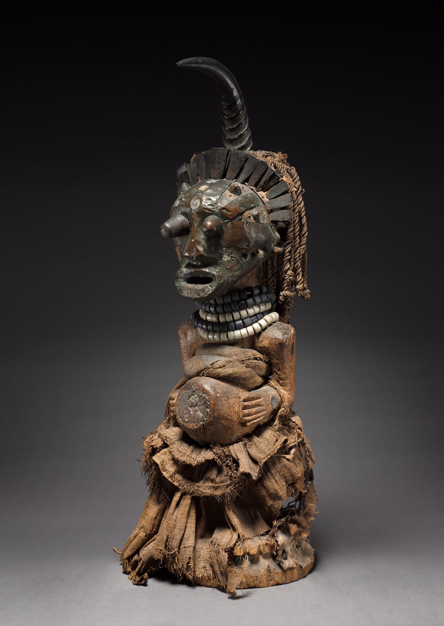 Wooden sculpture with intricate carvings on a gray background