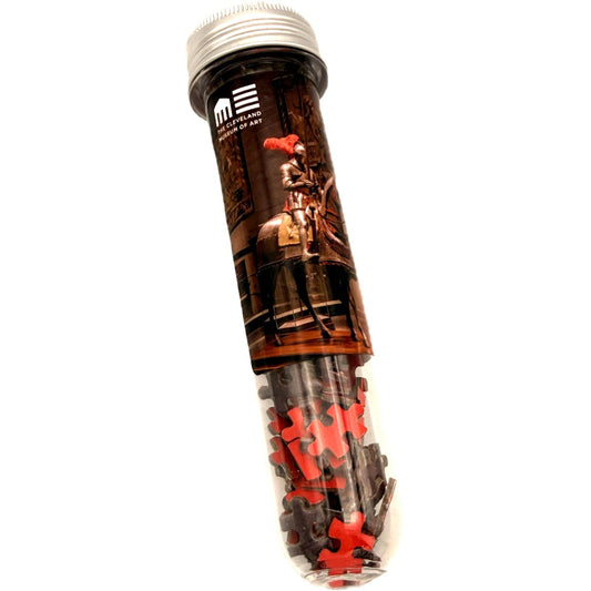 Tubular packaging with puzzle pieces and a graphic of a person on a horse, featuring the Cleveland Museum of Art brand.