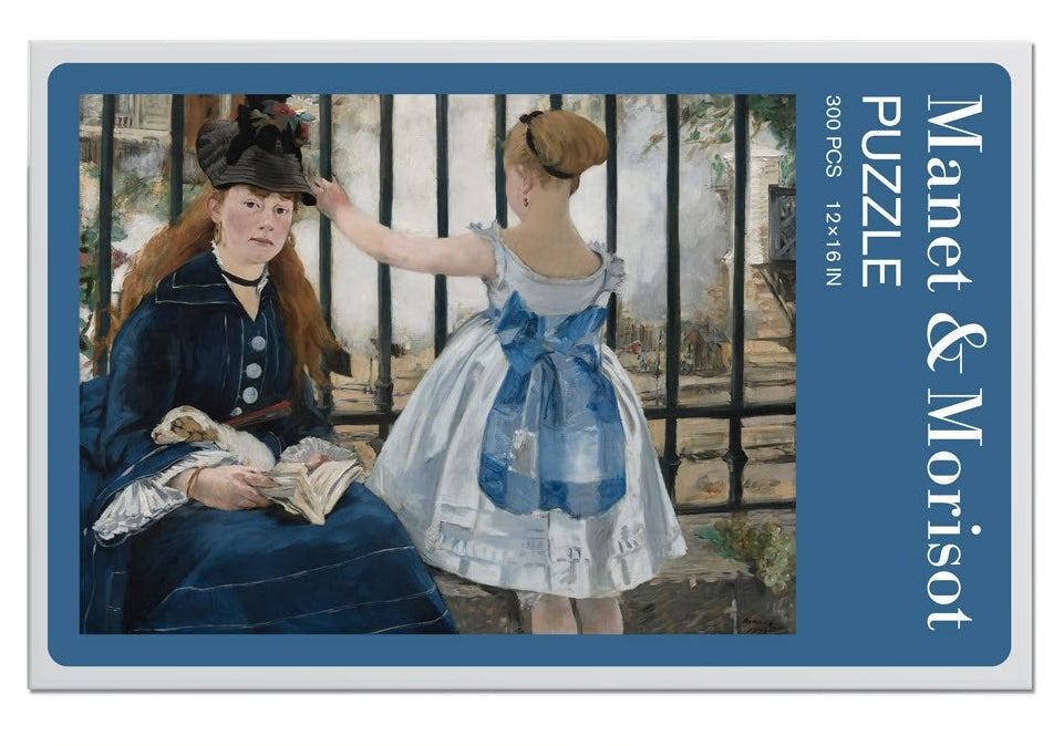 Jigsaw puzzle packaging with two women and a dog, featuring a blue ribbon and 'Manet & Morisot' branding.