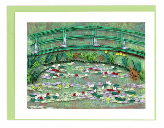 Framed artwork of a garden scene with a bridge over a pond.