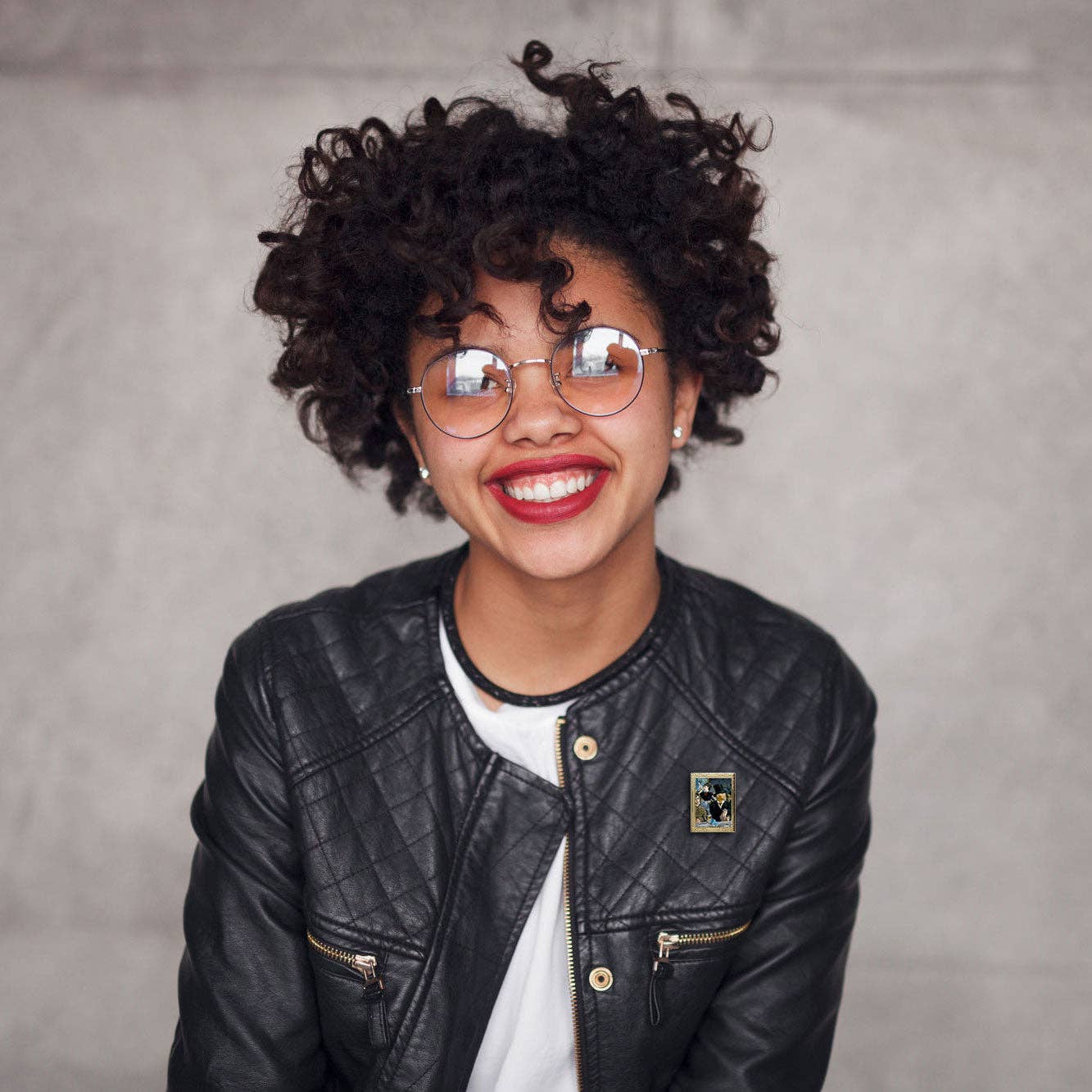 Person wearing a black leather jacket with a gray background